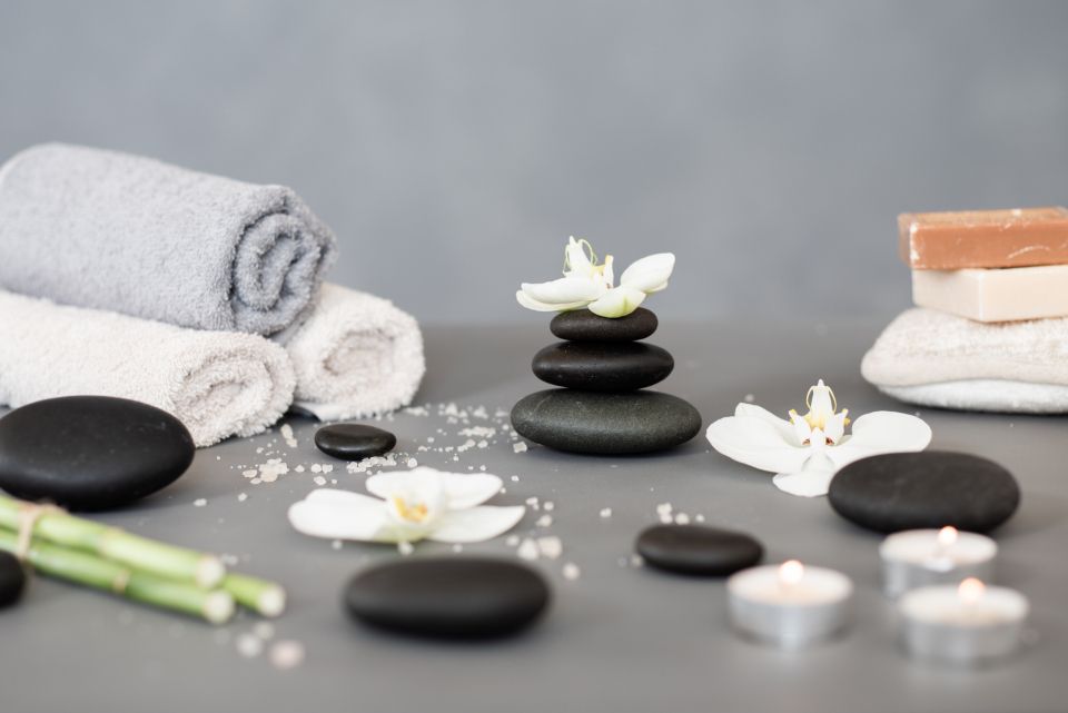 Zwarte hotstones, opgerolde handdoeken en orchidee