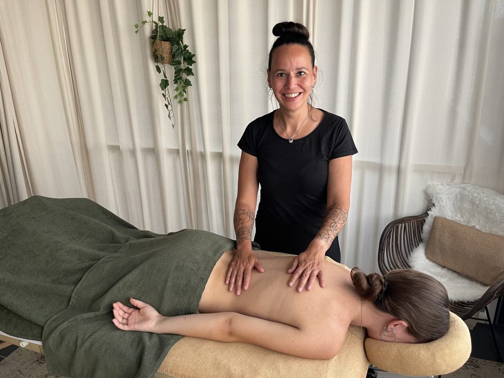 Tamara geeft een rugmassage aan een klant in haar praktijk in Hoofddorp