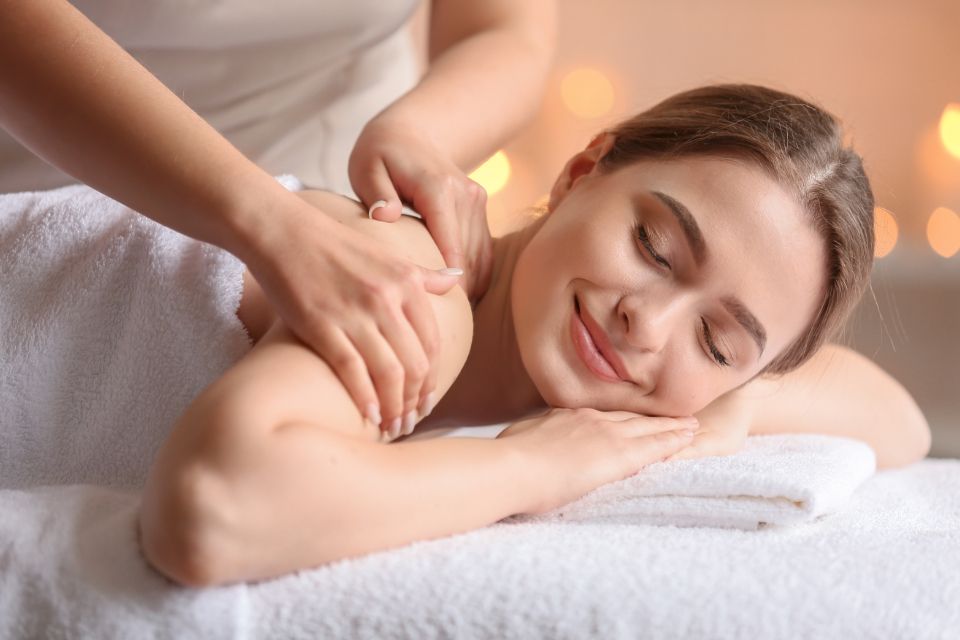 Vrouw ontspant met gesloten ogen tijdens een schoudermassage